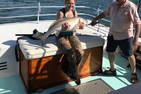 Lady angler with bull Red Drum (Redfish).